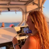 Patrona al timón de la lancha durante la navegación